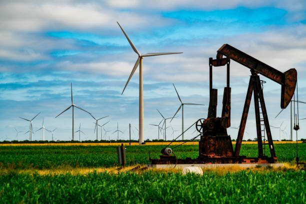 Old Oil Pump in front of Huge Wind Turbines in Wind Farm Fossil Fuel Extraction , fraacking , and Oil Pump pumping oil out of the ground in West Texas with Wind Turbines surrounding landscape - new and old technology , producing energy istock images stock pictures, royalty-free photos & images