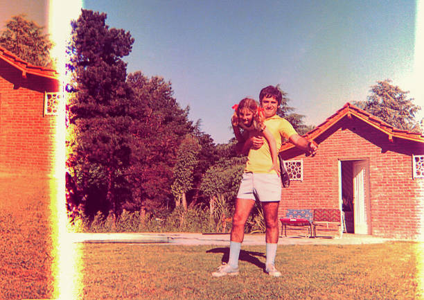 Foto vintage dan rusak seorang gadis dan ayahnya bermain di luar ruangan