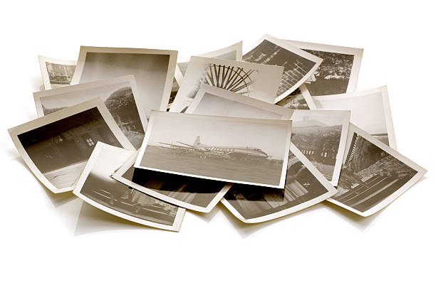 Old photographs in a pile of the Great Depression Pile of old faded photographs from the family album with soft shadows and reflections stack photos stock pictures, royalty-free photos & images