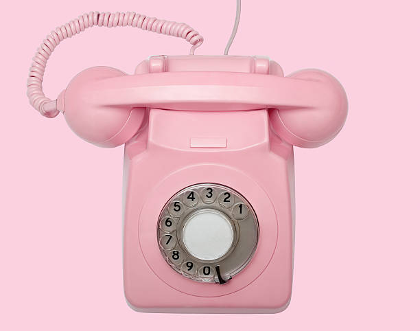 Old pink telephone on pink background with path stock photo