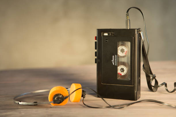 Old portable cassette player and headphones on a abstract background. Vintage advertisement style stock photo