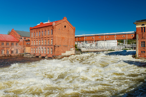 Kouvola, Finland - 15 September 2020: Old red brick buildings of Upm factory on rapids Kuusankoski.
