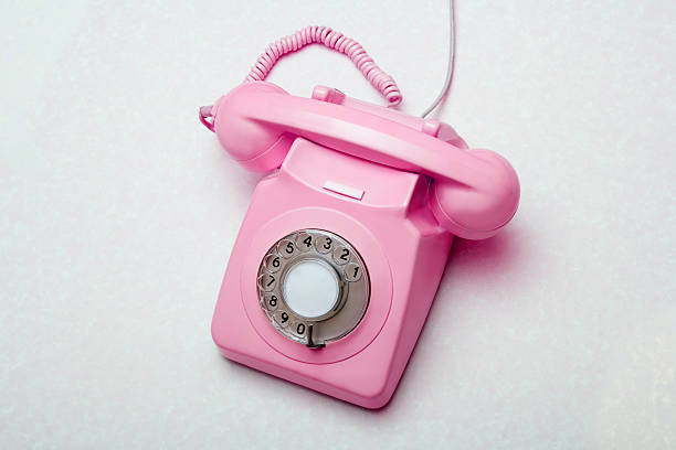 Old retro pink telephone on grey background stock photo