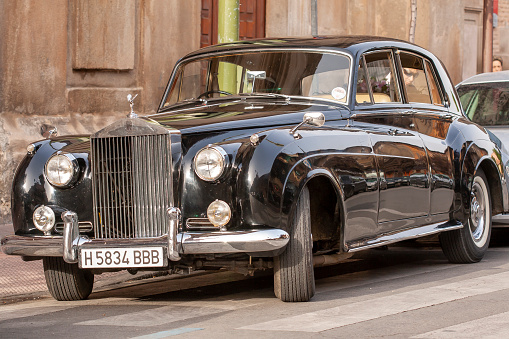 Alcala de Henares, Madrid, SPAIN - October 11, 2018: classic Rolls Royce silver cloud from 1957 parked at the door of the church waiting for the newlyweds. one of the most rented classics for weddings