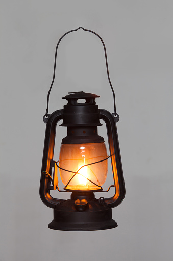 old vintage rusty kerosene black lamp isoleted on gray background. Glass oil lamp. Storm lantern. object vintage concept