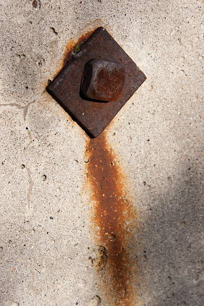 Old rusty screw in concrete wall. stock photo