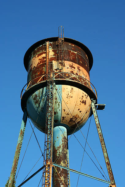 Old rusty watertower against blue sky stock photo