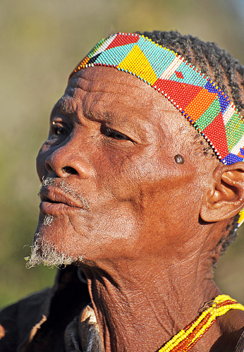 Portrait of old San bushman, Makgadikgadi Pans, Botswana, Southern Africa. The San are an ancient indigenous tribal people who inhabited much of southern Africa and although few in number today remain proud of their culture, ancestry and traditional ways of dress, customs and behaviour that included subsistence hunting and foraging