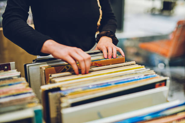 Old school music is the best music Shot of a young woman shopping for vinyl records at a store thrift store photos stock pictures, royalty-free photos & images