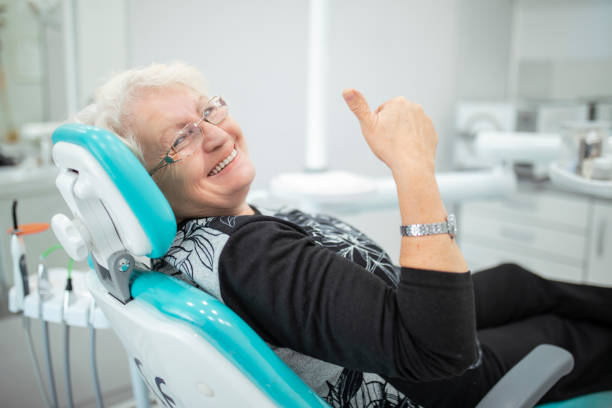 alte seniorin sitzt in einem zahnarztstuhl - zahnpflege stock-fotos und bilder