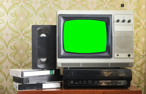 Old silver vintage TV with green screen to add new images to the screen, VCR on wallpaper background. Old silver vintage TV with green screen to add new images to the screen, VCR on wallpaper background. 90s television set stock pictures, royalty-free photos & images