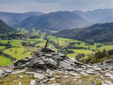 The old slate quarry, Castle Crag and green pastures of the Borrowdale valley, Lake District, UK.