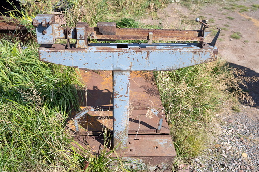 Old Soviet mechanical freight scales stand on the grass in summer.