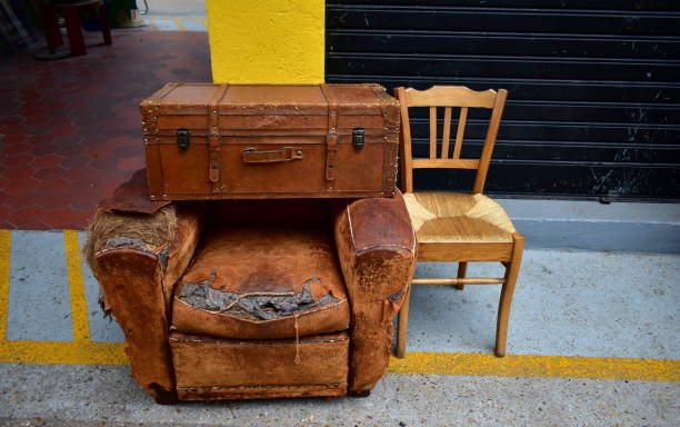 Old suitcase, sofa and chair on a street market. Vintage objects on a street market. broken suitcase stock pictures, royalty-free photos & images