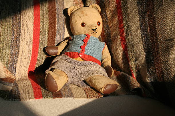 Old Teddy Bear Old teddy bear sitting on couch teddy ray stock pictures, royalty-free photos & images