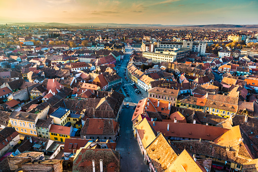 Color image depicting the ancient, medieval skyline of Sibiu, a city in the Transylvania region of Romania. In the foreground we can see two orthodox church spires, while beyond we can see traditional Germanic architecture of the town's buildings and houses spread out. Room for copy space.