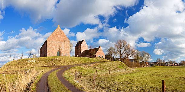 Old village on a mound ('terp'), Ezinge, Groningen, The Netherlands The old village of Ezinge in the northern province of Groningen. In The Netherlands, to protect villages from the nearby sea, houses were build on high man-made mounds, called a 'terp' or 'wierde' in Dutch. A seamlessly stitched panoramic image. groningen city stock pictures, royalty-free photos & images