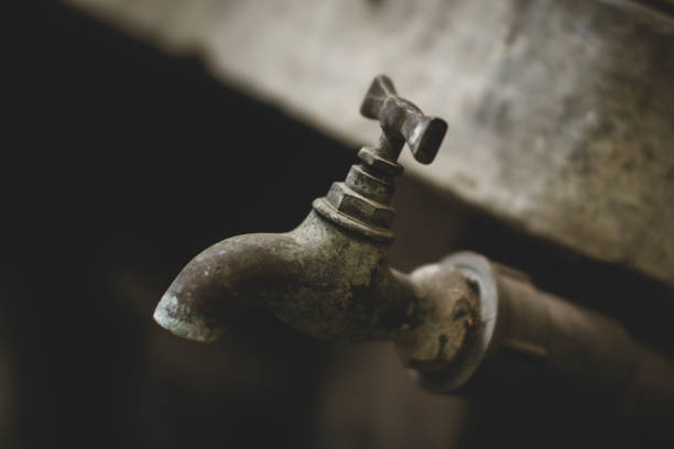 Old vintage brass tap on PVC pipe stock photo