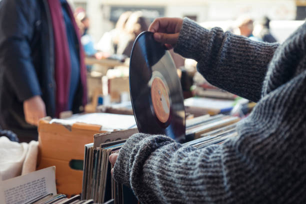 Old vinyl discs flea market Customer browsing vybyl discs at a vintage flea market. flea market photos stock pictures, royalty-free photos & images