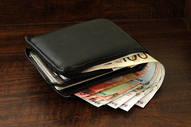 old wallet full with cash money stock photo