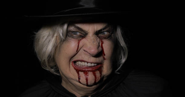 Old witch Halloween woman portrait. Elderly vampire woman with...