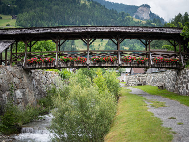 Old wooden bridge with flowers in Matrei in Osttirol Old wooden bridge with flowers in Matrei in Osttirol on a cloudy day in summer osttirol stock pictures, royalty-free photos & images