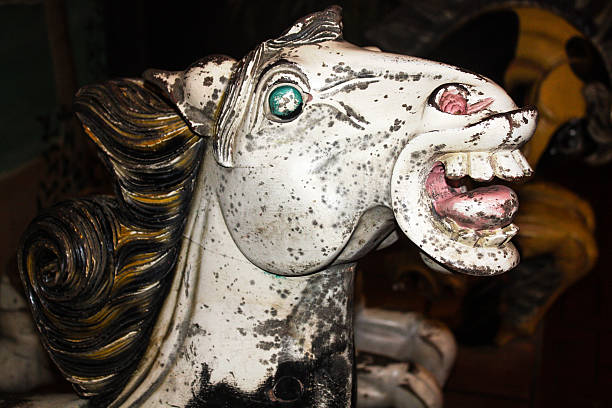 old wooden horse head very closeup scary and creepy old horse head from an old merry go round from the early 1900's, green eye and mouth open in a creepy way carousel horses stock pictures, royalty-free photos & images