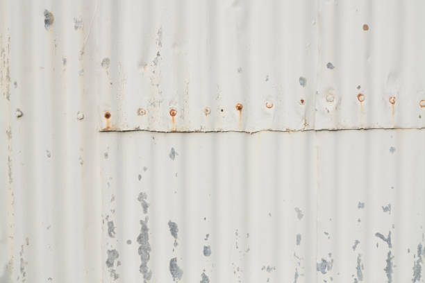 Old worn white corrugated steel texture on exterior wall. stock photo