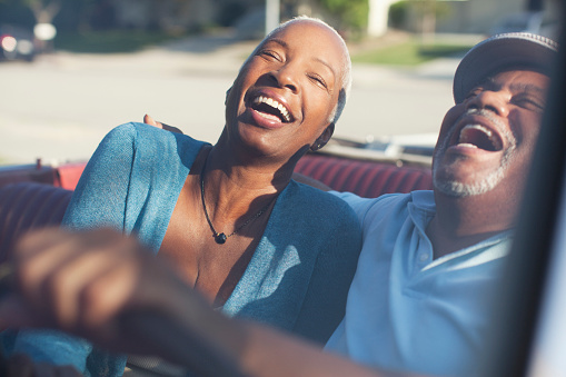 Older couple laughing in convertible