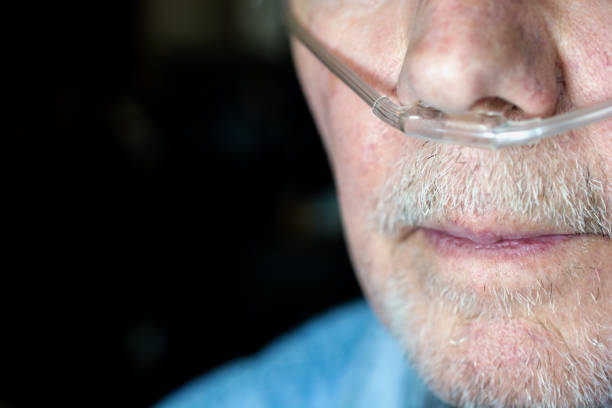Older man's face with oxygen cannula being used stock photo