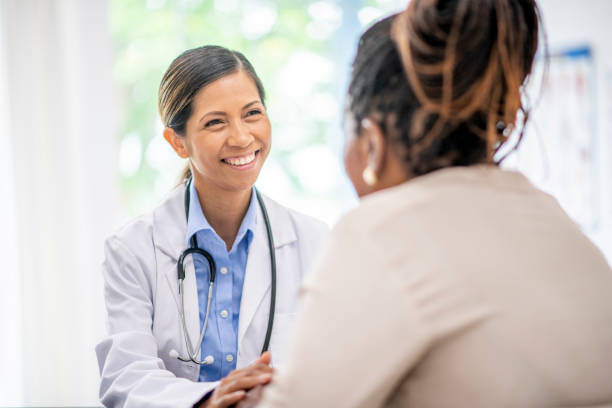 Older woman in medical consultation with her doctor African American woman at a medical appointment with her doctor. female doctor stock pictures, royalty-free photos & images