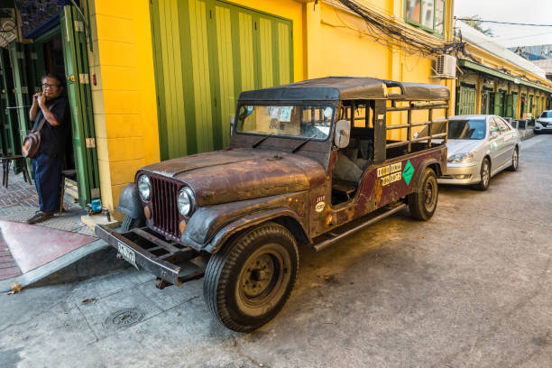 oldtimer willys jeep die bij straat in bangkok, thailand wordt geparkeerd - front view old jeep stockfoto's en -beelden