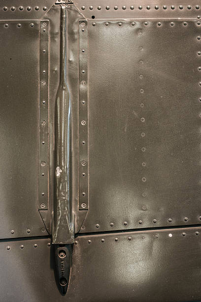 Olive drab plane panel with rivets  and aileron linkage. Olive drab exterior of a plane with riveted panel lines.  Aileron linkage for tail flaps. linkage effect stock pictures, royalty-free photos & images
