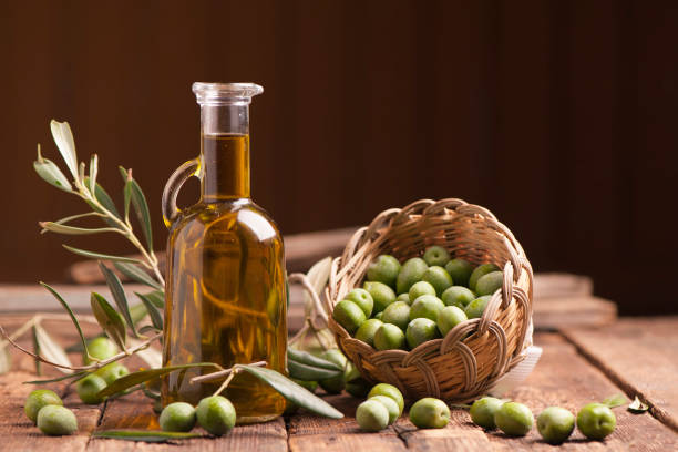Olive oil and olives Olive oil and olives on wooden rustic table olive oil stock pictures, royalty-free photos & images