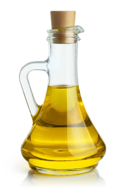 Olive oil on white Delicious olive oil in a glass bottle, isolated on white background cooking oil stock pictures, royalty-free photos & images
