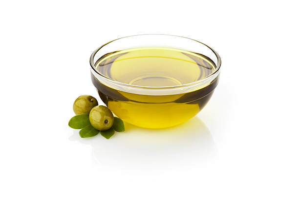 Olive oil Olive oil and green olives with leaves in glass bowl sitting on reflective white backdrop.  DSRL studio photo taken with Canon EOS 5D Mk II and Canon EF 70-200mm f/2.8L IS II USM Telephoto Zoom Lens olive oil stock pictures, royalty-free photos & images