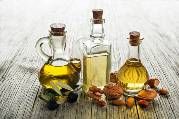 Olive, walnut, almond oil Olive, walnut and almond oil on wooden background cooking oil stock pictures, royalty-free photos & images