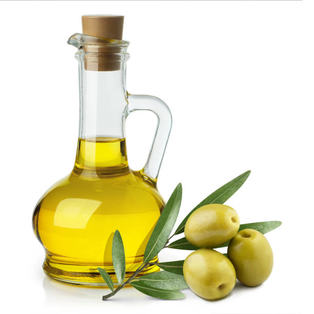 Olives on white Delicious olive oil in a glass bottle and green olives with leaves, isolated on white background green olives jar stock pictures, royalty-free photos & images