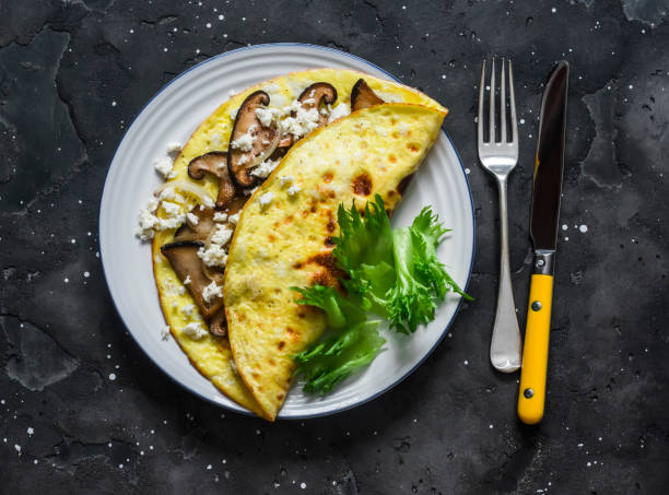 Omelet with shiitake and eringi mushrooms - delicious, healthy, vegetarian brunch on a dark background, top view stock photo