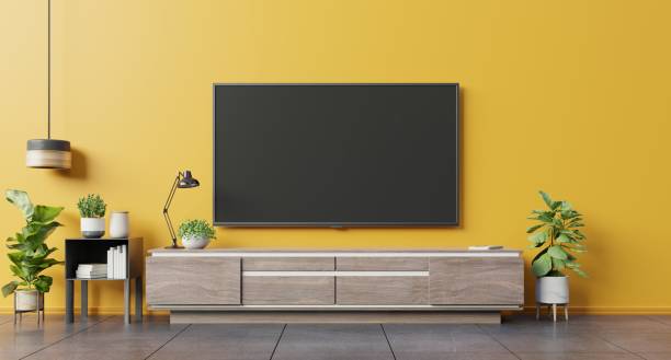 tv sur l'armoire dans le salon moderne sur le fond jaune de mur. - tv photos et images de collection