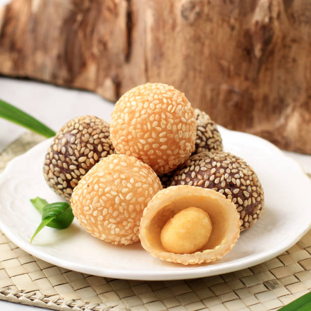 Onde-Onde is traditional food from Indonesia made from glutinous rice flour with beans pasta, wrapped in sesame seeds. Popular Indonesian  with Chinese influence. Served in white plate, close up. stock photo
