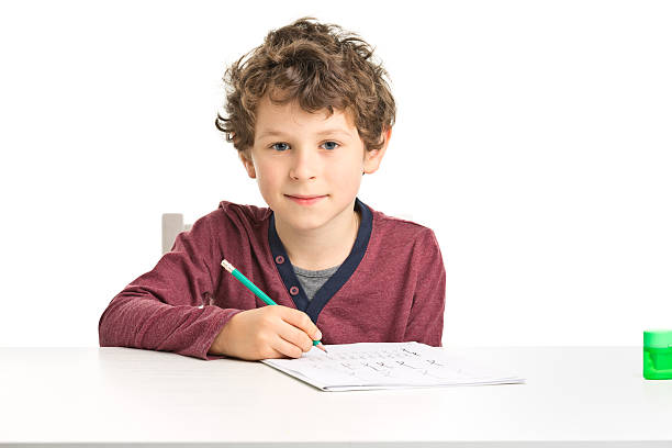 one 7 years old boy doing homework stock photo