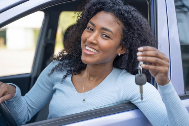 One black woman very happy exhibits her key car stock photo