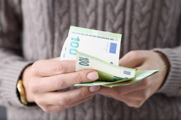 One hundred euro banknotes in female hands stock photo