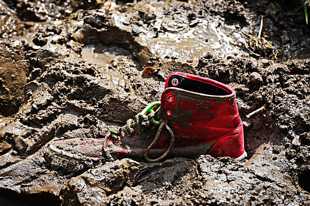 one left behind. - muddy shoes stockfoto's en -beelden