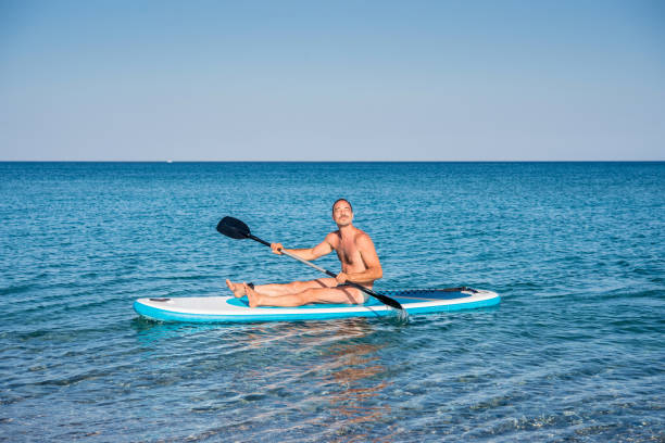 One Man Paddle Boarding Alone on the Sea stock photo