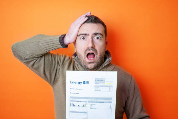 One man worried about bills reading energy increase costs isolated on background stock photo