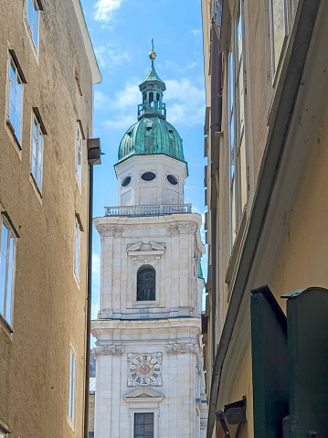 One of the clock and bell towers of Salzburg Cathedral, Austria. viewed through aa narrow alley.
