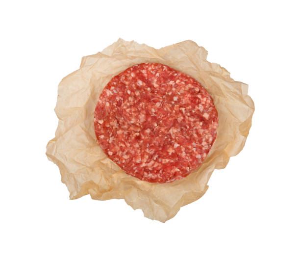 One raw beef meat hamburger isolated on white One fresh raw beef meat burger for hamburger wrapped in brown paper parchment isolated on white background, elevated top view, directly above burger wrapped in paper stock pictures, royalty-free photos & images