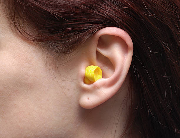 One single ear with a ear plug in it stock photo